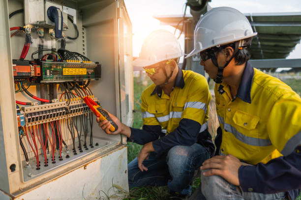 electricians at work Workers use clamp meter to measure the current of electrical wires produced from solar energy for confirm to normal current.